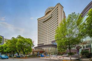 ein hohes Gebäude in einer Stadt mit Bäumen in der Unterkunft Nanchang Oriscene Garden Hotel in Nanchang