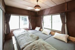 une chambre avec deux lits dans une pièce avec fenêtres dans l'établissement Sunland S152 - Vacation STAY 54960v, à Mihara