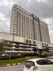 a white car parked in front of a large building at AnR Studio Suite Inside H Elite Building in Kota Bharu