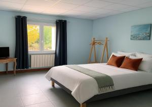 a bedroom with a large bed and a window at L'Arbre de Vie in Montmarault