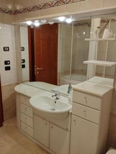 a white bathroom with a sink and a mirror at Fattoria I Canarini in Fossalta di Piave