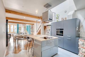 eine Küche mit blauen Schränken und einem Esszimmer in der Unterkunft La Petite Maison Centrale - T4 - Centre Montluel in Montluel