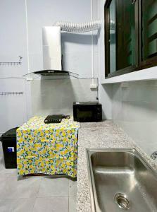 una cocina con fregadero y una caja en la encimera en Bird Hostel Chiangrai, en Chiang Rai