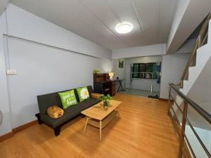 una sala de estar con un sofá y una mesa en Bird Hostel Chiangrai, en Chiang Rai