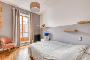 ein Schlafzimmer mit einem Bett, einem Stuhl und einem Fenster in der Unterkunft La Petite Maison Centrale - T4 - Centre Montluel in Montluel
