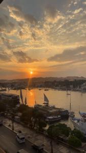 a sunset over a harbor with boats in the water at Anuket House in Naj‘ al Maḩaţţah