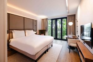 a bedroom with a large bed and a desk and a table at Kasteel Steenenburg in Den Bosch