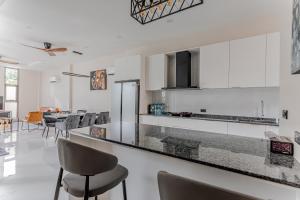 a kitchen with white cabinets and a black counter top at Modern 3 Bed Pool Villa Chaweng -Whispering Palm Villa A in Bang Rak Beach