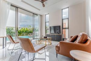 a living room with a couch and a tv at Modern 3 Bed Pool Villa Chaweng -Whispering Palm Villa A in Bang Rak Beach