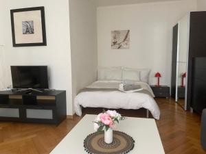 Una sala de estar con una cama y un televisor. en Appartement calme à Lausanne, en Lausana