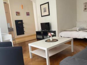 sala de estar con mesa blanca y cama en Appartement calme à Lausanne, en Lausana 1 foto más
