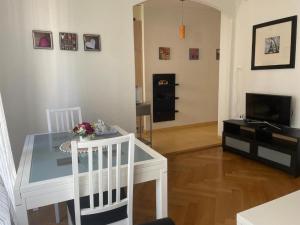 sala de estar con mesa blanca y TV en Appartement calme à Lausanne, en Lausana