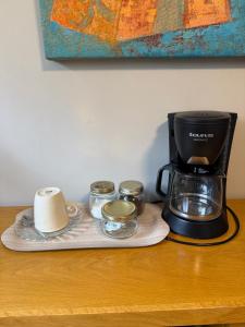 a coffee maker and cups on a wooden table at A 5 min de IFEMA, 10 del aeropuerto, Una o dos camas dobles con baño privado, entrada independiente in Madrid +12 photos