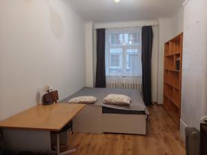 a bedroom with a bed and a desk and a window at Comfy apartment with 2 bedrooms in Riga