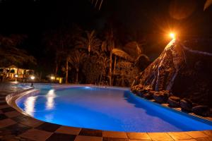 ein Schwimmbad bei Nacht mit blauer Beleuchtung in der Unterkunft Naibor Villa in Themi