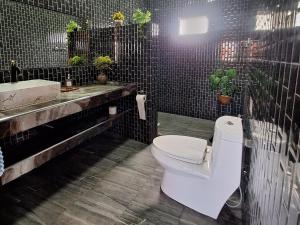 une salle de bain avec des toilettes blanches et un lavabo dans l'établissement บ้านน้ำผึ้งโฮมสเตย์, à Suan Phueng 99 autres photos