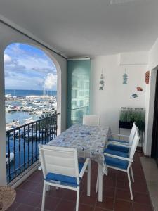 a table and chairs on a balcony with a view of a harbor at Marina Real 2391 in Manilva