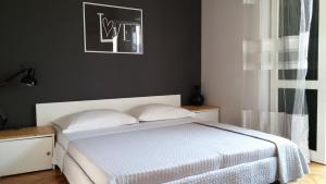 トゥチェピにあるTucepi For Twoの白いベッドと黒い壁のベッドルーム1室