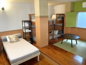 a room with a bed and a table and bunk beds at HOTEL 紅-bin- in Okinawa City +61 photos