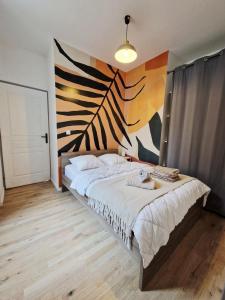 a bedroom with a large bed with a painting on the wall at Les appartements de Lucie in Eaux-Bonnes