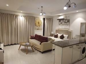 un soggiorno con un divano e un tavolo di Hawana Salalah Rosely Studio a Salalah