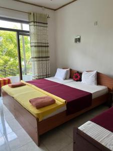 une chambre avec deux lits et une fenêtre dans l'établissement Kandy IVY Banks Holiday Resort, à Kandy