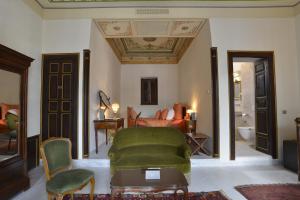 uma sala de estar com uma cadeira verde e um sofá em Palais Bayram em Tunes