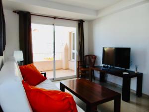 卡勒达德福斯特Casita Playa Castillo 3A的客厅里有一张沙发、一张桌子和一台电视