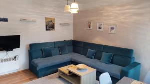 a living room with a blue couch and a table at Apartman Vlašićki san in Vlasic