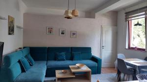 a living room with a blue couch and a table at Apartman Vlašićki san in Vlasic