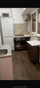 a kitchen with a white refrigerator and a sink at Apartament ultracentral in Craiova
