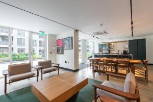 Una sala de estar con mesas y sillas y una cocina. en Urban Rest - Dublin Port, en Dublín