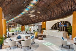 Xóm TramAmigo Sol Phan Thiet的度假村大堂的效果图，图中可见桌椅。