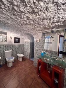 a bathroom with a sink and a toilet and a mirror at Casa Triana in Cuevas del Campo