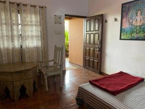 a bedroom with a bed and a table and a chair at Anjuna Hideout in Anjuna