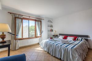 ein Schlafzimmer mit einem großen Bett und einem Fenster in der Unterkunft Can Xilla by Sealand Villas in Alcanada + 9 Fotos