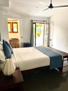 une chambre avec un grand lit avec un ventilateur de plafond dans l'établissement Casa Smeralda, à Batigama 61 autres photos