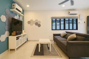 un soggiorno con un divano e una TV di Tekun Landed D'Family Pickeball Fun House 5BR14pax by Our Stay a Johor Bahru