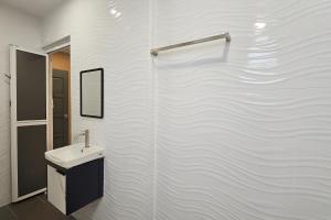 un bagno bianco con lavandino e specchio di Tekun Landed D'Family Pickeball Fun House 5BR14pax by Our Stay a Johor Bahru Altre 57 foto