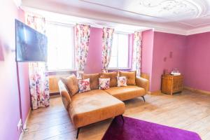 un salon avec un canapé et une télévision dans l'établissement Gasthof Römischer Kaiser, à Ellingen