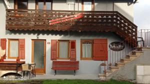 ein Haus mit einer roten Bank davor in der Unterkunft Les cols in Sainte-Marie-de-Cuines