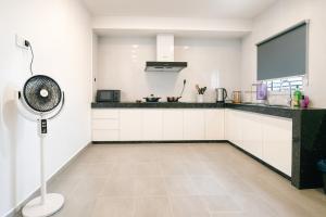 una cucina con armadietti bianchi e un ventilatore di Tekun Landed D'Family Pickeball Fun House 5BR14pax by Our Stay a Johor Bahru