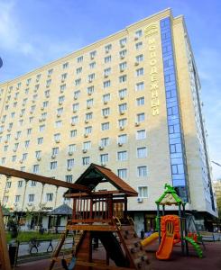 a hotel with a playground in front of a building at Arbat Central Apartment in Almaty