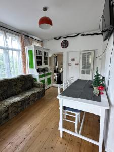 a living room with a table and a couch at Apartament La poteca ursului in Buşteni