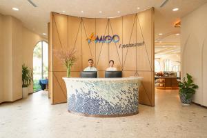 Xóm TramAmigo Sol Phan Thiet的两个人站在大厅的接待处 更多27张照片