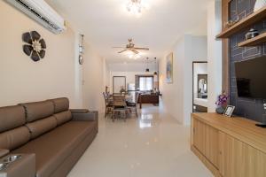 a living room with a couch and a dining room at Baan Piengfah Holiday Home Ao Nang in Ao Nang Beach