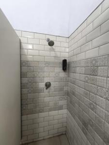 a bathroom with a shower with white tiles at Antique Hostel in Bucharest