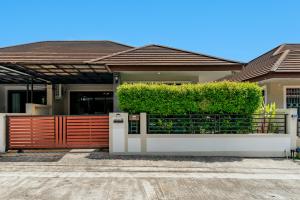 a house with a red fence and bushes at Baan Piengfah Holiday Home Ao Nang in Ao Nang Beach