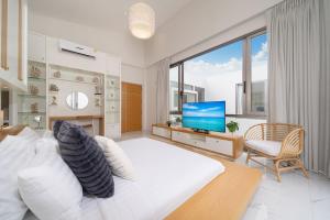 ein Schlafzimmer mit einem großen weißen Bett und einem Fernseher in der Unterkunft Villa Casa Koko - Luxury Modern Minimalism in Thalang + 87 Fotos