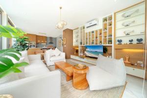 ein Wohnzimmer mit weißen Möbeln und einem Tisch in der Unterkunft Villa Casa Koko - Luxury Modern Minimalism in Thalang